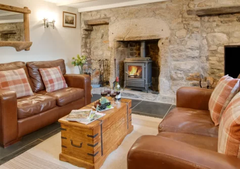 Sunset Farmhouse, Carnyorth is an exceptional Grade II-listed 18th-century retreat near St Just, featuring granite walls, exposed beams, wood burners in three rooms, two enclosed courtyards with a chimenea, and direct access to West Penwith's coast.