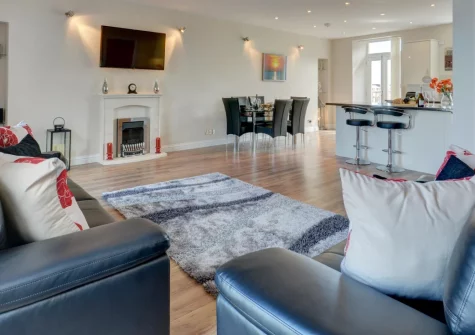 Sunset View, Ilfracombe is a spacious second-floor apartment featuring six private balconies with spectacular harbour and sea views, contemporary coastal interiors, and an unbeatable location moments from Victorian Tunnels Beaches and the harbour.