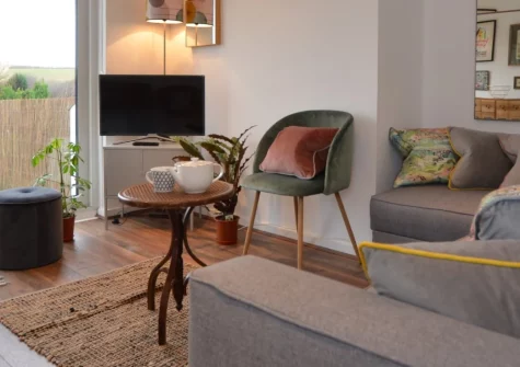 Surf's Up, Widemouth Bay is a beautifully presented two-bedroom cottage just a short stroll from one of North Cornwall's finest sandy surfing beaches, featuring eclectic coastal interiors, a sunny tiered patio, and easy access to legendary Tintagel.