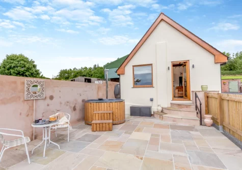 The large enclosed patio, outdoor sitting area & hot tub at Swallows Nest, Ford