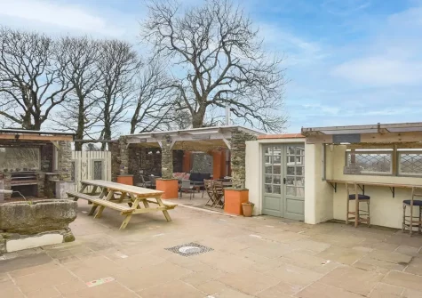 Incredible outdoor space with covered cooking facilities, dining area & comfortable seating