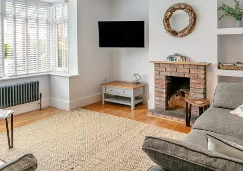 Syringa, Beer is a stylish three-bedroom retreat just a short distance from the beach in this charming Jurassic Coast village, featuring bi-fold doors opening onto tiered gardens, a garden room workspace, and easy access to coastal walks.