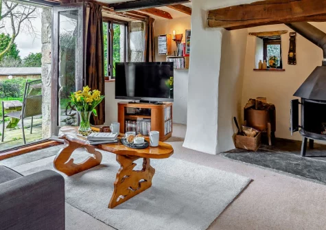 Tawnawood, Fletchersbridge is a characterful converted Cornish barn set within peaceful countryside, featuring cosy interiors with wood-burning stove, far-reaching valley views, and direct access to Cardinham Woods for forest adventures.