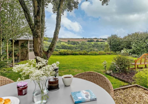 The alfresco dining area, summer house & rear garden at Thatch View Cottage, Roborough