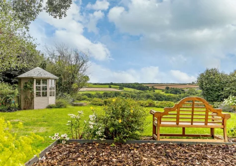 The rear garden, with summer house & beautiful views over the fields toward Dartmoor, at Thatch View Cottage, Roborough