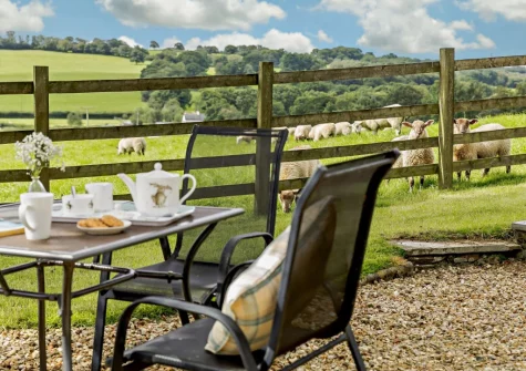 Enjoy fantastic far-reaching countryside views from the alfresco dining area & lawned garden at The Arch Barn, South Molton