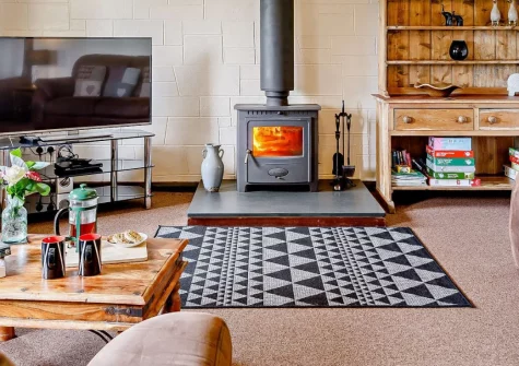 The Arch Barn, South Molton is a stunning reverse-level conversion on a 300-acre working farm bordering Exmoor, featuring charming arched windows, a cosy wood burner, and peaceful countryside views, with North Devon's beaches and coast nearby.
