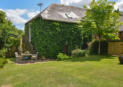 The patio, alfresco dining area & lawned garden at The Barn, Hittisleigh