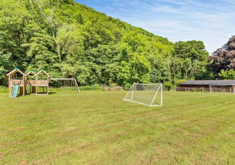 The play area with children's climbing frame at The Barton, Martinhoe