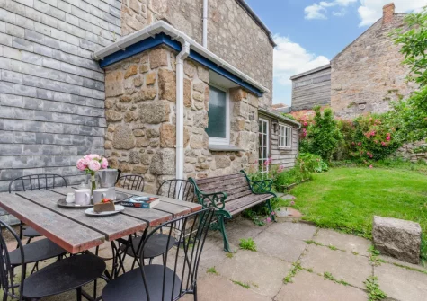The patio, alfresco dining area & enclosed cottage-style garden at The Blue House, Penzance