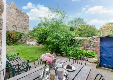 The patio, alfresco dining area & enclosed cottage-style garden at The Blue House, Penzance