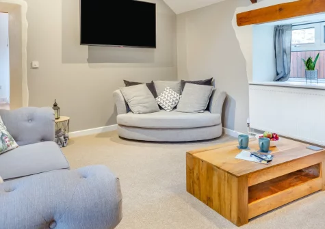The Byre at Home Farm, Yeolmbridge is a stylish three-bedroom barn conversion near Launceston, featuring a private hot tub, sociable kitchen, cosy wood-burner snug, and easy access to Devon and Cornwall's coast, moors and countryside for exploring.