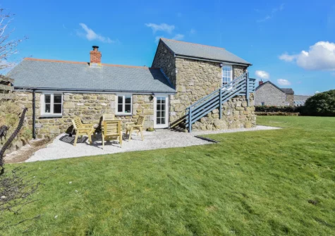 The patio, alfresco dining area & large enclosed lawned garden at The Byre, Sennen