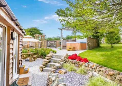 The patio, alfresco dining area, hot tub & garden at The Cabin Retreat, Luxulyan