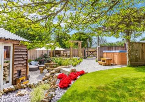 The patio, alfresco dining area, hot tub & garden at The Cabin Retreat, Luxulyan
