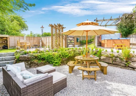 The patio, outdoor sitting, alfresco dining area, hot tub & garden at The Cabin Retreat, Luxulyan