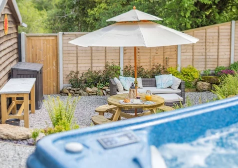 The patio, alfresco dining area & hot tub at The Cabin Retreat, Luxulyan