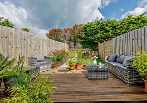 The rear enclosed garden with decked patio & outdoor sitting area at The Chimes, Brixham
