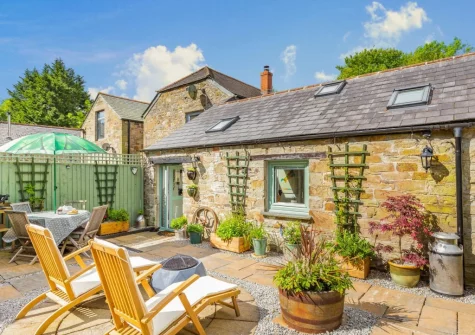 The enclosed garden, with alfresco dining & sitting area, at The Churns, Lanhydrock