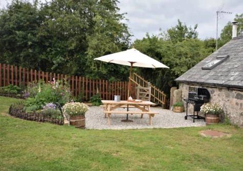 The patio, barbecue, alfresco dining area & dog friendly enclosed garden at The Coach House, Whiddon Down