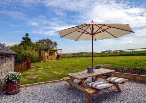 The patio, barbecue, alfresco dining area & dog friendly enclosed garden at The Coach House, Whiddon Down