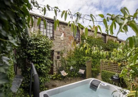 The small enclosed garden, hot tub, barbecue & outdoor sitting area at The Corner Cottage, Carnhell Green