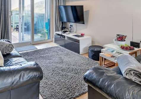 The Cove, Porthtowan is a contemporary 2-bedroom ground-floor apartment with enclosed patio. Just steps from a top surfing beach, it's perfect for families seeking authentic Cornish coastal holidays with easy access to local attractions.