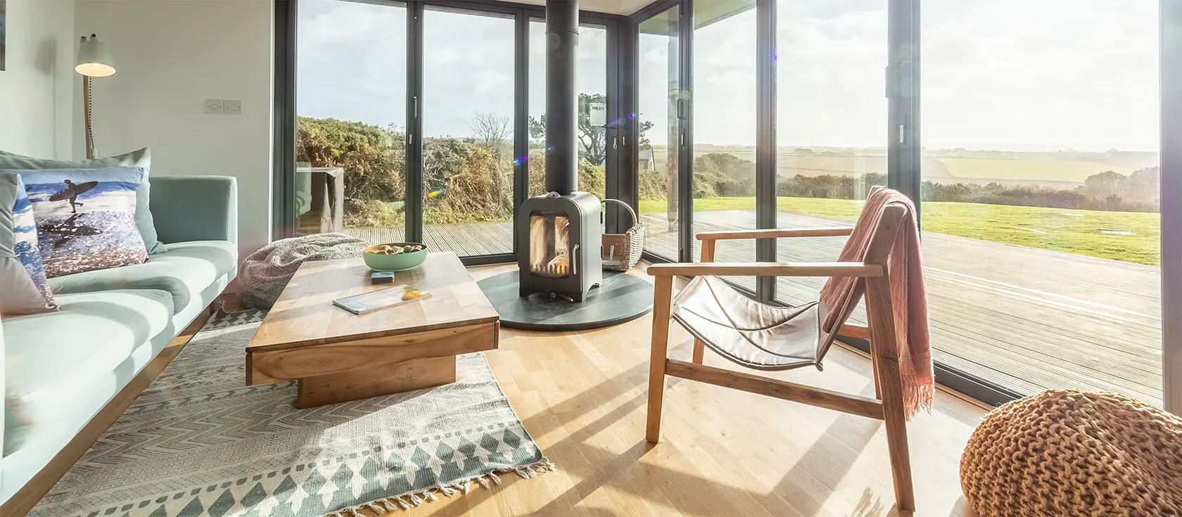 The Deck House, Goonvrea is a countryside eco-home with stunning coastal views from bifold doors & private deck. Open floorplan, modern kitchen & contemporary woodburner. Two bedrooms & two bathrooms are ideal for four guests. Walk to beach & St Agnes pubs.