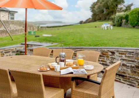 The patio, alfresco dining area & large enclosed garden at The Dreyhouse, St Issey
