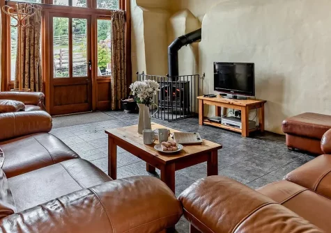 The Granary, Bittadon is a stunning converted stone barn on a working farm with magnificent exposed beams, private patio, and access to delightful on-site animal experiences. Perfect for families seeking countryside charm near Devon's coast.