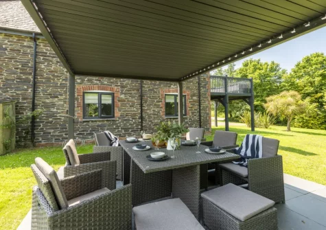 The pergola-covered patio, barbecue & alfresco dining area at The Hawthorns at Roserrow, Polzeath