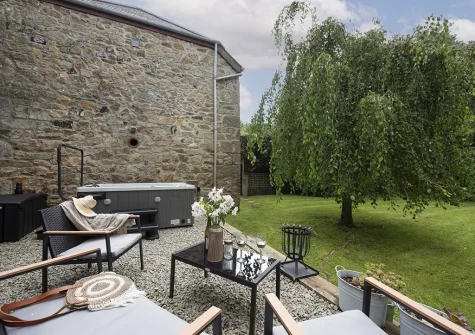 The patio, outdoor sitting area, hot tub & garden at The Hay Loft, Carnhell Green