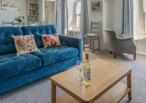 The Kellan, Mousehole is a characterful five-bedroom cottage wrapped around a private suntrap courtyard. Features include a remarkable library with baby grand piano, traditional Aga kitchen, and stunning sea views. Perfect literary retreat.
