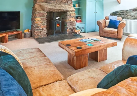 The Long Barn, St Ervan is a beautifully converted 18th-century stone barn in peaceful countryside near Padstow, featuring a cosy wood burner, inverted layout with three bedrooms, enclosed patio, and easy access to Cornwall's stunning beaches.