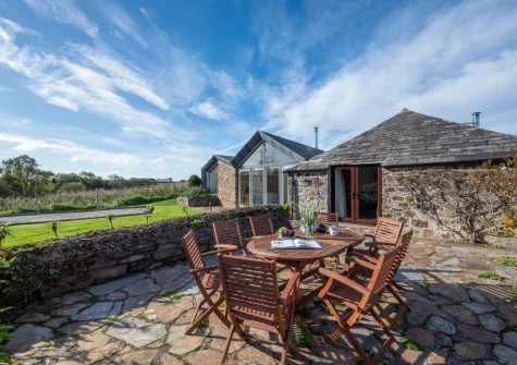 The patio, barbecue, alfresco dining area & enclosed lawned garden at The Mowhay, St Minver