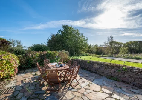 The patio, barbecue, alfresco dining area & enclosed lawned garden at The Mowhay, St Minver