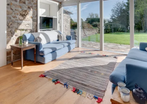 The Mowhay, St Minver is a beautifully restored six-bedroom barn conversion near Cornwall's north coast, featuring original beams and granite walls, a games room with table football, enclosed gardens with boules pitch, and flexible accommodation.