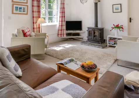 The Old Mill Cottage, Advent is a charming barn conversion within a 16th-century manor's grounds, featuring open-plan living with original stonework, a wood burner, and peaceful Camel Valley views with walking trails from the door.