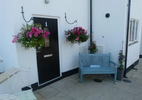 The small patio with outdoor sitting area at The Old Sail Loft, Beer