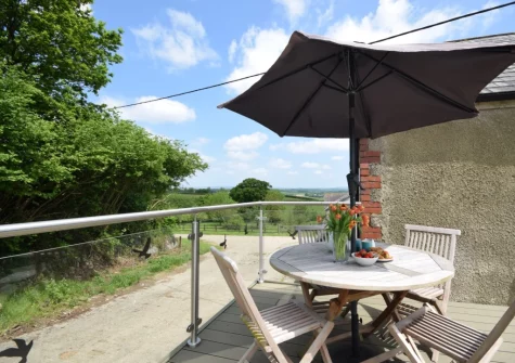 The decked patio, alfresco dining area & hot tub at The Owl Barn at Lower Langaton Farm, Chittlehampton