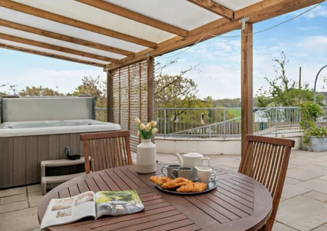 The patio, alfresco dining area & hot tub at The Piggery, High Bickington