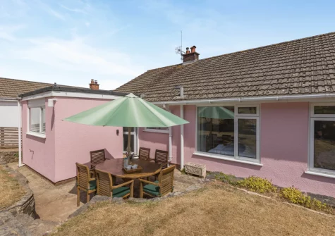 The patio, alfresco dining area & tiered garden at The Pink Beach Bungalow, Paignton