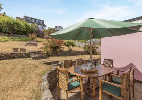 The patio, alfresco dining area & tiered garden at The Pink Beach Bungalow, Paignton