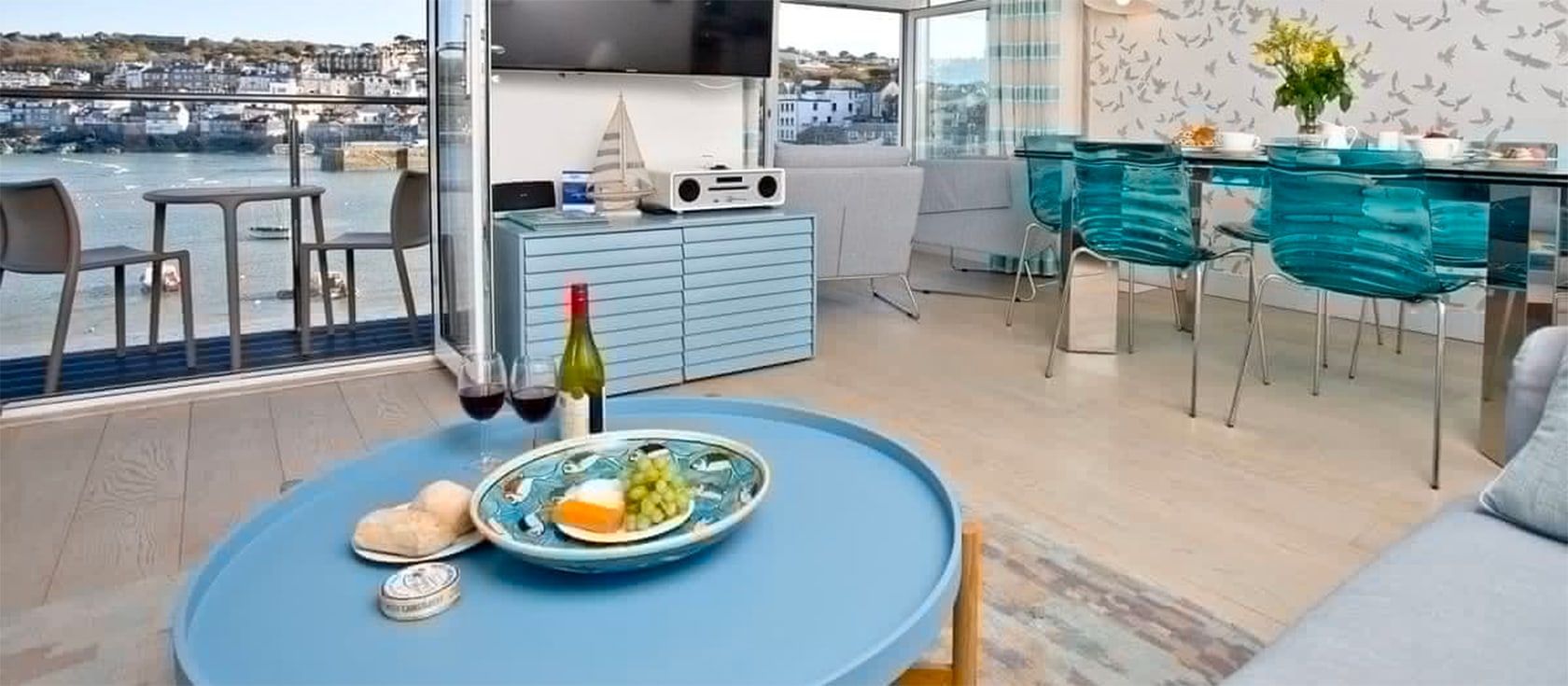 The Poop Deck, 3 Harbour House, St Ives is a three bedroom property for six with stunning harbour and bay views. The modern interior leads onto a covered balcony for dining. This 5-star luxury apartment includes private parking & surfboard storage.