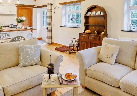 The Shippen at Upper Yeoland, Swimbridge is a charming barn conversion in North Devon countryside. Enjoy flexible sleeping arrangements, an enclosed courtyard with BBQ, and easy access to golden beaches and attractions. Perfect for families.