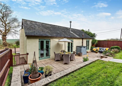 The rear patio, alfresco dining, sitting area & garden at The Shippon, Hembury Gate Farm, Sheepwash