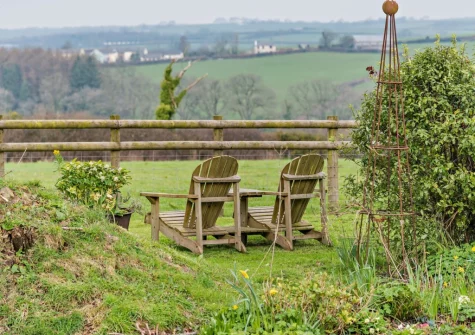 The front garden & outdoor sitting area, with far reaching countryside views, at The Shippon, Hembury Gate Farm, Sheepwash