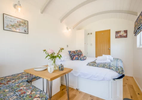 The shepherd's hut dining area & bedroom at The Smithy, Feock