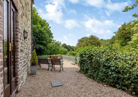 The enclosed gravelled outdoor sitting, barbecue & alfresco dining area at The Stable, Dunmere