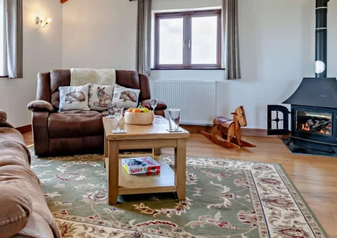 The Stables at Brea Farm, Trevegean is a stylish reverse-level barn conversion offering panoramic countryside and ocean views, with a private balcony overlooking the Scilly Isles, enclosed garden, and easy access to Sennen Cove's stunning beach.